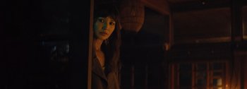 Movie still from “The Creator” (2023), directed by Gareth Edwards – A woman standing in a dark room looking out of a window; Close Up shot, Low angle