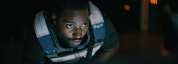 Movie still from “The Creator” (2023), directed by Gareth Edwards – A person wearing a space suit; Close Up shot, Overhead angle