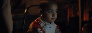 Movie still from “The Creator” (2023), directed by Gareth Edwards – A young boy wearing a space suit and headphones; Close Up shot, Low angle