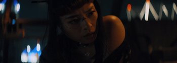 Movie still from “The Creator” (2023), directed by Gareth Edwards – A young woman with dark hair and a necklace on; Close Up shot, Low angle