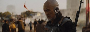 Movie still from “The Creator” (2023), directed by Gareth Edwards – An older man wearing a helmet and headphones; Close Up shot, Over the shoulder angle