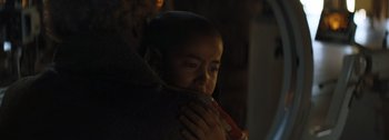 Movie still from “The Creator” (2023), directed by Gareth Edwards – A young child is holding on to a blanket; Close Up shot, Over the shoulder angle