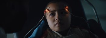 Movie still from “The Creator” (2023), directed by Gareth Edwards – A young child with wires attached to their ears; Close Up shot, Low angle