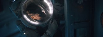 Movie still from “The Creator” (2023), directed by Gareth Edwards – A person is reflected in a round mirror; Close Up shot, Overhead angle