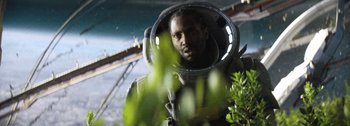 Movie still from “The Creator” (2023), directed by Gareth Edwards – A man in a space suit is reflected in a mirror; Close Up shot, Low angle