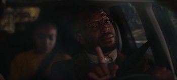 Movie still from “The Curse of Bridge Hollow” (2022), directed by Jeff Wadlow – A man in a car giving the peace sign; Close Up shot, Over the shoulder angle