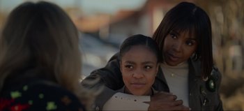 Movie still from “The Curse of Bridge Hollow” (2022), directed by Jeff Wadlow – Two young women posing for a picture on a city street; Close Up shot, Over the shoulder angle