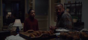 Movie still from “The Curse of Bridge Hollow” (2022), directed by Jeff Wadlow – A man and a woman standing in front of a box of donuts; Medium shot, Over the shoulder angle