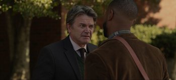 Movie still from “The Curse of Bridge Hollow” (2022), directed by Jeff Wadlow – A man wearing a suit and tie talking to another man; Close Up shot, Over the shoulder angle