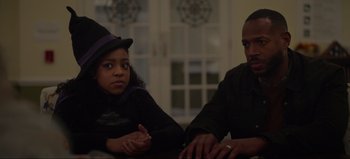 Movie still from “The Curse of Bridge Hollow” (2022), directed by Jeff Wadlow – A man and a woman sitting next to each other at a table; Medium shot, Over the shoulder angle