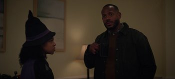 Movie still from “The Curse of Bridge Hollow” (2022), directed by Jeff Wadlow – A man is talking to another man in a living room; Medium shot, Over the shoulder angle