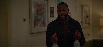 Movie still from “The Curse of Bridge Hollow” (2022), directed by Jeff Wadlow – A man holding a spray bottle in a room; Close Up shot, Over the shoulder angle