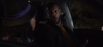 Movie still from “The Curse of Bridge Hollow” (2022), directed by Jeff Wadlow – A man sitting in the back of a car with a woman; Close Up shot, Over the shoulder angle