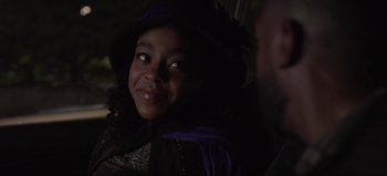 Movie still from “The Curse of Bridge Hollow” (2022), directed by Jeff Wadlow – A young woman wearing a purple hat and a black dress; Close Up shot, Over the shoulder angle