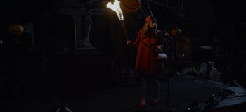 Movie still from “The Curse of Bridge Hollow” (2022), directed by Jeff Wadlow – A woman holding a lit torch in the dark; Wide shot, High angle