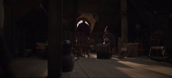 Movie still from “The Curse of Bridge Hollow” (2022), directed by Jeff Wadlow – Two people are sitting in a room with luggage; Wide shot, Low angle