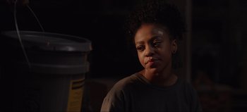 Movie still from “The Curse of Bridge Hollow” (2022), directed by Jeff Wadlow – A young woman sitting in front of a trash can; Close Up shot, Over the shoulder angle