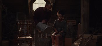 Movie still from “The Curse of Bridge Hollow” (2022), directed by Jeff Wadlow – A man and a woman pouring wine into a barrel; Medium shot, Low angle