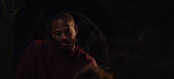 Movie still from “The Curse of Bridge Hollow” (2022), directed by Jeff Wadlow – A man in a maroon shirt is looking down; Close Up shot, Over the shoulder angle