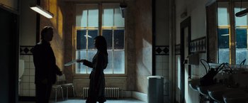 Movie still from “The Da Vinci Code” (2006), directed by Ron Howard – A woman is walking in a room by a window; Wide shot, Over the shoulder angle
