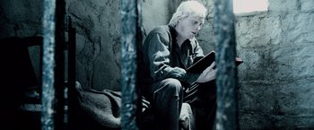 Movie still from “The Da Vinci Code” (2006), directed by Ron Howard – A man sitting on the ground looking at a tablet computer; Medium shot, Overhead angle