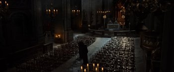 Movie still from “The Da Vinci Code” (2006), directed by Ron Howard – A person is standing in a dark room with many chairs; Extreme Wide shot, High angle