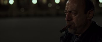 Movie still from “The Da Vinci Code” (2006), directed by Ron Howard – A person holding a cigar in his mouth; Close Up shot, Low angle