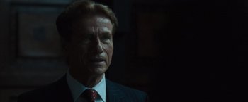 Movie still from “The Da Vinci Code” (2006), directed by Ron Howard – An older man in a suit and red tie; Close Up shot, Over the shoulder angle