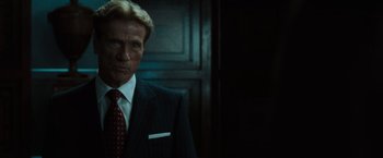 Movie still from “The Da Vinci Code” (2006), directed by Ron Howard – A man in a suit and tie standing in front of a wall; Close Up shot, Low angle