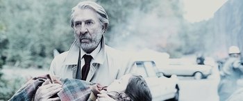 Movie still from “The Da Vinci Code” (2006), directed by Ron Howard – An older man in a trench coat holding a young girl; Close Up shot, Over the shoulder angle