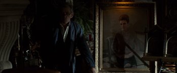 Movie still from “The Da Vinci Code” (2006), directed by Ron Howard – A man standing in front of a mirror in a dark room; Medium shot, Over the shoulder angle