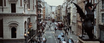 Movie still from “The Da Vinci Code” (2006), directed by Ron Howard – A busy city street with cars and people on the sidewalk; Extreme Wide shot, High angle