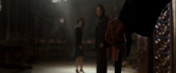 Movie still from “The Da Vinci Code” (2006), directed by Ron Howard – A man holding a cane in front of a woman in a black dress; Extreme Close Up shot, Over the shoulder angle