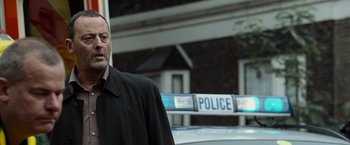 Movie still from “The Da Vinci Code” (2006), directed by Ron Howard – A man standing in front of a police car; Close Up shot, Over the shoulder angle