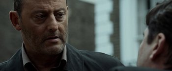 Movie still from “The Da Vinci Code” (2006), directed by Ron Howard – A man's face in front of a brick building; Close Up shot, Over the shoulder angle