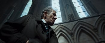 Movie still from “The Da Vinci Code” (2006), directed by Ron Howard – An older man wearing a coat and tie; Close Up shot, Low angle