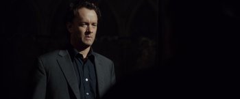 Movie still from “The Da Vinci Code” (2006), directed by Ron Howard – A man wearing a suit and a black shirt; Close Up shot, Over the shoulder angle