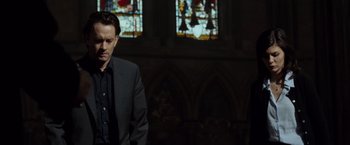 Movie still from “The Da Vinci Code” (2006), directed by Ron Howard – A man standing in front of a stained glass window; Medium shot, Low angle