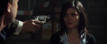 Movie still from “The Da Vinci Code” (2006), directed by Ron Howard – A person holding a gun pointed at a woman; Close Up shot, Over the shoulder angle
