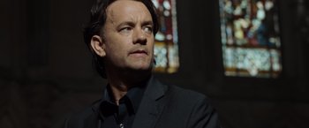 Movie still from “The Da Vinci Code” (2006), directed by Ron Howard – A man in a black suit looking to his left; Close Up shot, Low angle