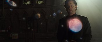 Movie still from “The Da Vinci Code” (2006), directed by Ron Howard – A man standing in front of a stained glass window; Medium shot, Low angle