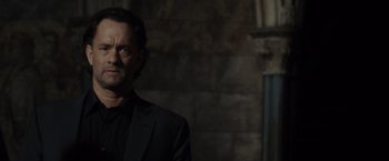 Movie still from “The Da Vinci Code” (2006), directed by Ron Howard – A man wearing a suit standing in front of a brick wall; Close Up shot, Low angle
