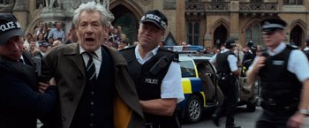 Movie still from “The Da Vinci Code” (2006), directed by Ron Howard – A police officer is standing in front of a crowd of onlookers; Medium shot, Low angle