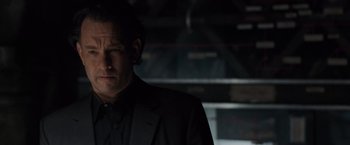 Movie still from “The Da Vinci Code” (2006), directed by Ron Howard – A man in a black suit standing in a dark room; Close Up shot, Low angle