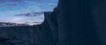 Movie still from “The Day After Tomorrow” (2004), directed by Roland Emmerich – A view of a mountain from the side of a cliff; Extreme Wide shot, Overhead angle