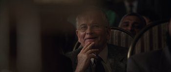 Movie still from “The Day After Tomorrow” (2004), directed by Roland Emmerich – An older man wearing a suit and tie; Close Up shot, Over the shoulder angle