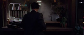 Movie still from “The Day After Tomorrow” (2004), directed by Roland Emmerich – A man in a suit standing in front of a counter; Medium shot, Low angle