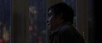Movie still from “The Day After Tomorrow” (2004), directed by Roland Emmerich – A man looking out of a window at a rainy night; Close Up shot, Over the shoulder angle