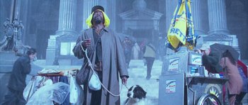 Movie still from “The Day After Tomorrow” (2004), directed by Roland Emmerich – A man and a dog are walking in the rain; Medium shot, Low angle
