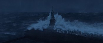 Movie still from “The Day After Tomorrow” (2004), directed by Roland Emmerich – The statue of liberty is surrounded by waves as the sun goes down; Extreme Wide shot, High angle